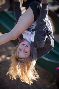 Lower School upside down girl on playground