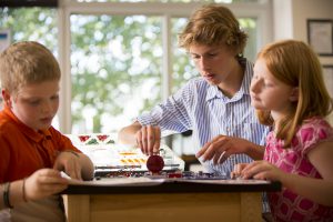 Upper School boy helping Lower School girl with STEAM project