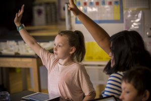 Lower School girls raising hands